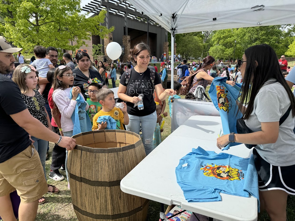 Families receiving festival shirts at Día del Niño Fest